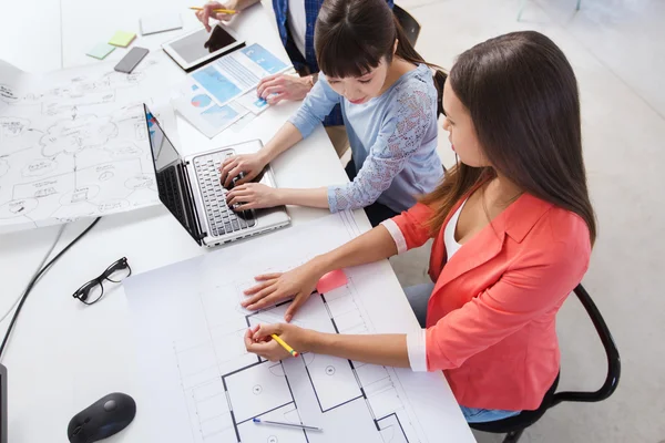 Creative team with laptop and blueprint at office — Stock Photo, Image