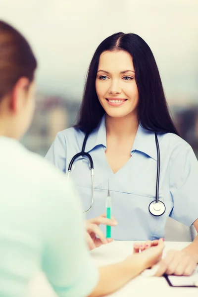 Smiling female doctor or nurse with syringe — Stock Photo, Image