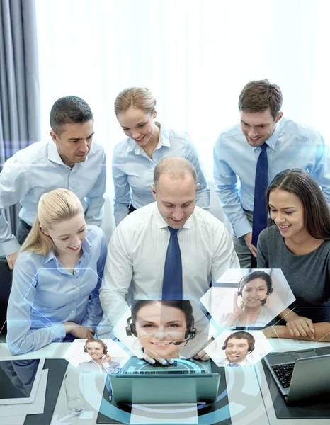 Des hommes d'affaires souriants avec ordinateur portable au bureau — Photo