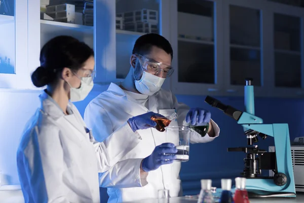 Perto de cientistas que fazem testes em laboratório — Fotografia de Stock