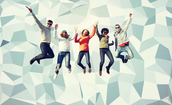 Smiling friends in sunglasses jumping high — Stock Photo, Image