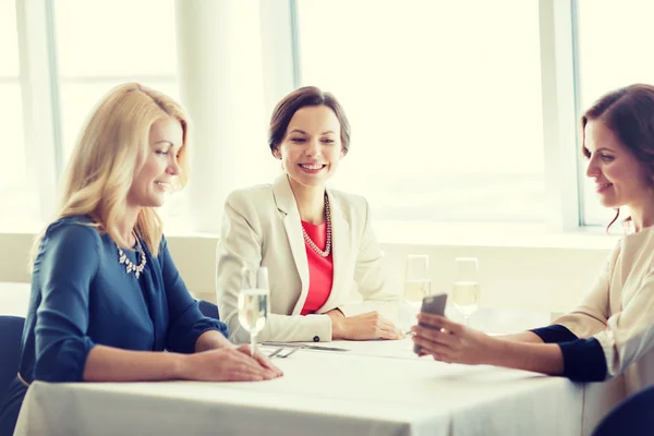 Gelukkig vrouwen met smartphone bij restaurant — Stockfoto