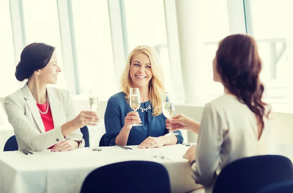 Happy women drinking champagne at restaurant — Stock Photo, Image