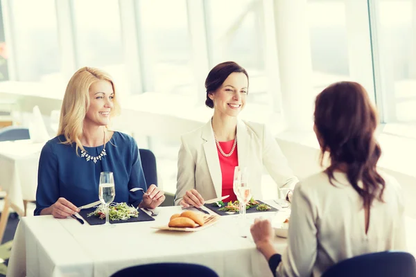 Mujeres felices comiendo y hablando en el restaurante —  Fotos de Stock