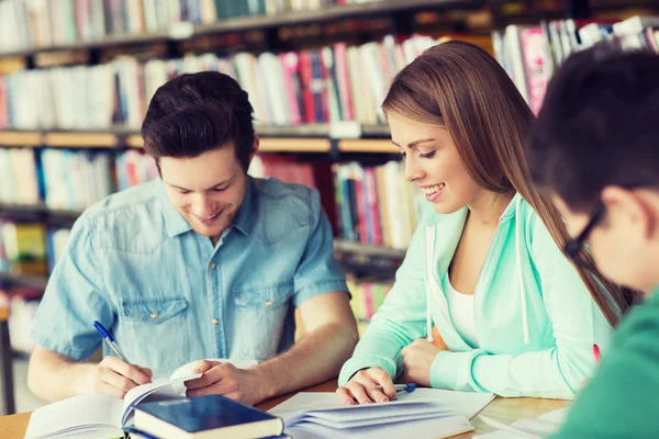 Estudantes com livros que se preparam para exame na biblioteca — Fotografia de Stock