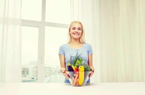 Jonge vrouw groenten thuis koken glimlachen — Stockfoto