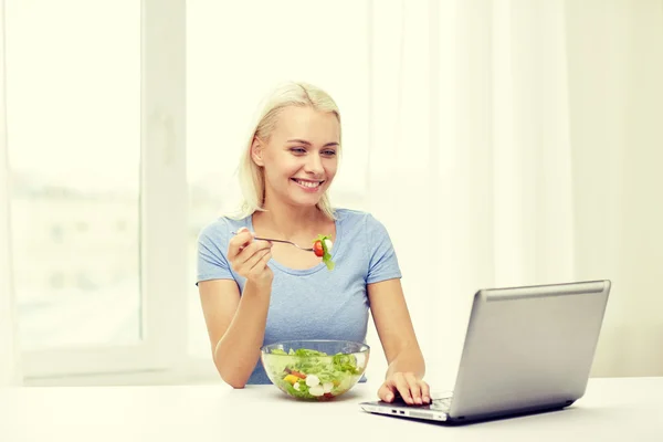Salata evde yemek dizüstü bilgisayar ile gülümseyen kadın — Stok fotoğraf