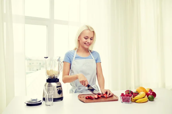 Leende kvinna med blender förbereder skaka hemma — Stockfoto