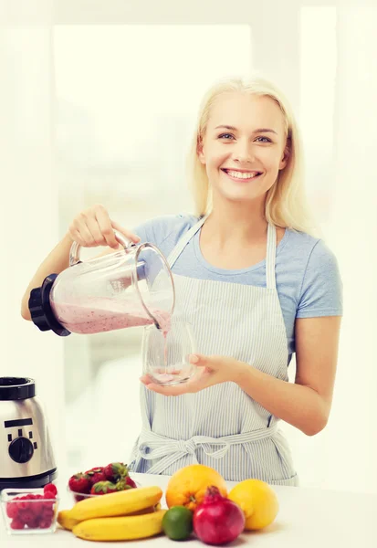 Mujer sonriente con licuadora preparando batido en casa —  Fotos de Stock