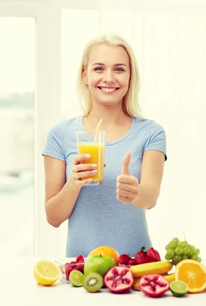 Woman drinking fruit juice and showing thumbs up — Stockfoto