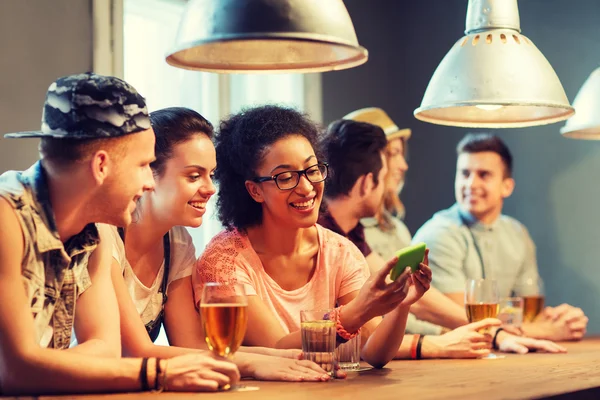 Amici felici con smartphone e bevande al bar — Foto Stock