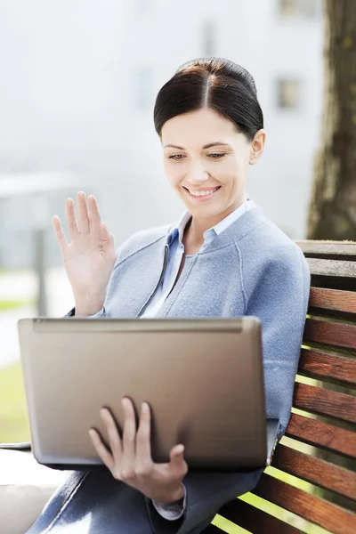 Uśmiechnięta kobieta biznesu z laptopa w mieście — Zdjęcie stockowe