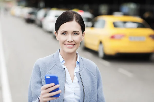 Улыбающаяся женщина со смартфоном на такси в городе — стоковое фото