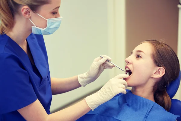 Kvinnliga tandläkare kontrollera patientens tjej tänder — Stockfoto