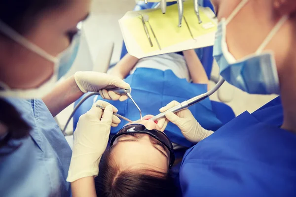 Dentistas mujeres que tratan los dientes de niña paciente — Foto de Stock