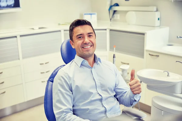 Homem feliz mostrando polegares na clínica odontológica — Fotografia de Stock