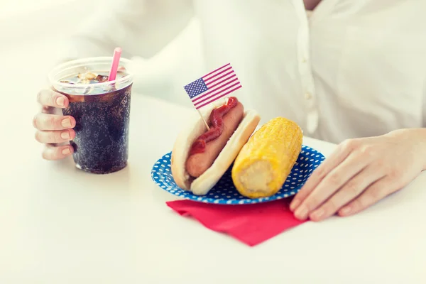 Close up of woman eating hot dog with cola — Stock Photo, Image