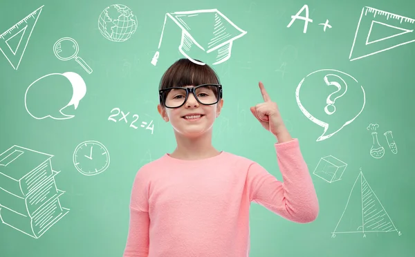 Glückliches kleines Mädchen mit Brille zeigt mit dem Finger nach oben — Stockfoto