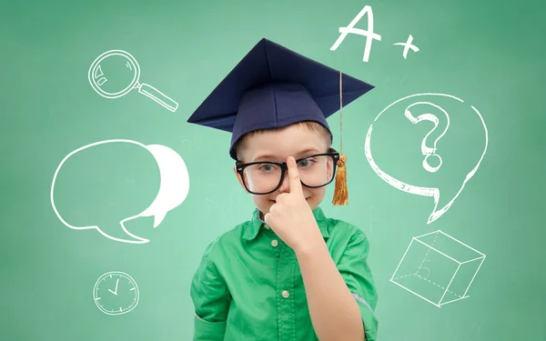 Boy in bachelor hat and eyeglasses over blackboard — Stock Photo, Image