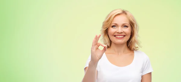 Lycklig kvinna i vit t-shirt visar ok hand tecken — Stockfoto