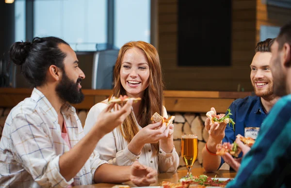 Freunde essen Pizza mit Bier im Restaurant — Stockfoto