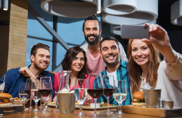 Vänner med selfie av smartphone på restaurang — Stockfoto