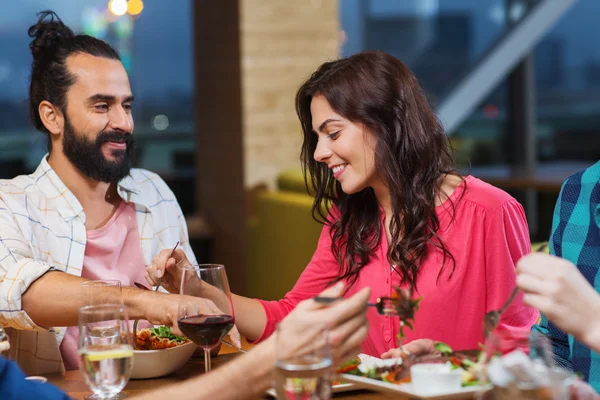 Friends eating and tasting food at restaurant — Stock Photo, Image