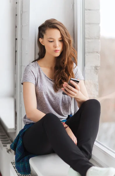 Üzgün oldukça genç kız ile smartphone manifatura — Stok fotoğraf