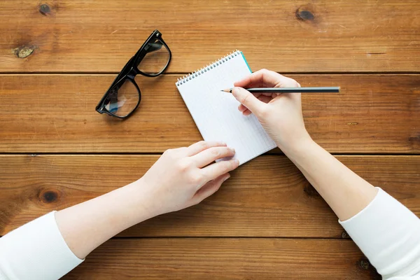 Close up of woman or student writing to notepad — Stock Photo, Image