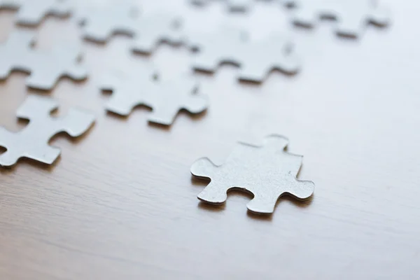 Close up de peças de quebra-cabeça na superfície de madeira — Fotografia de Stock