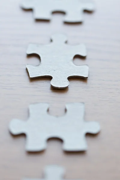 Close up van puzzelstukjes op houten oppervlak — Stockfoto