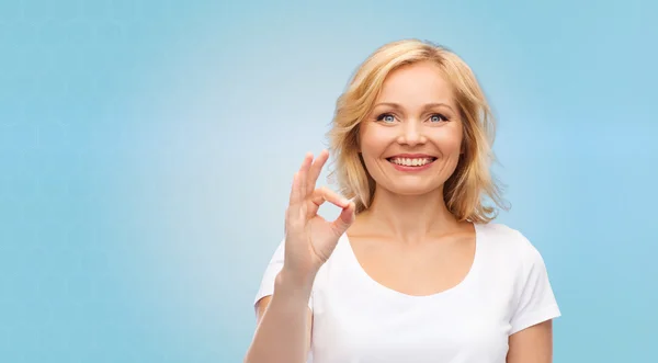 Mujer feliz en camiseta blanca mostrando señal de mano ok — Foto de Stock