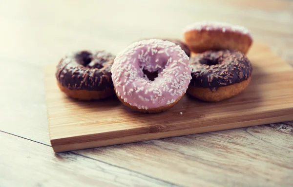 Närbild på glaserade donuts högen på träbord — Stockfoto