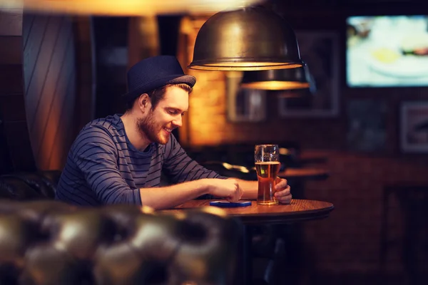 Uomo con smartphone e birra sms al bar Foto Stock Royalty Free