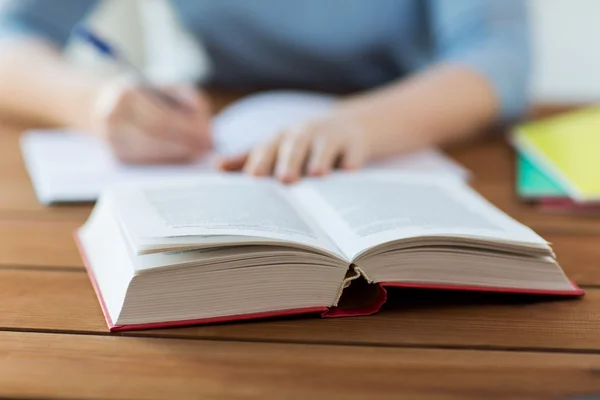 Nahaufnahme eines Studenten mit Buch und Notizbuch zu Hause — Stockfoto