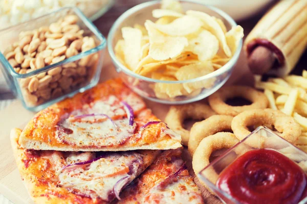 Närbild på snabbmat snacks på träbord — Stockfoto