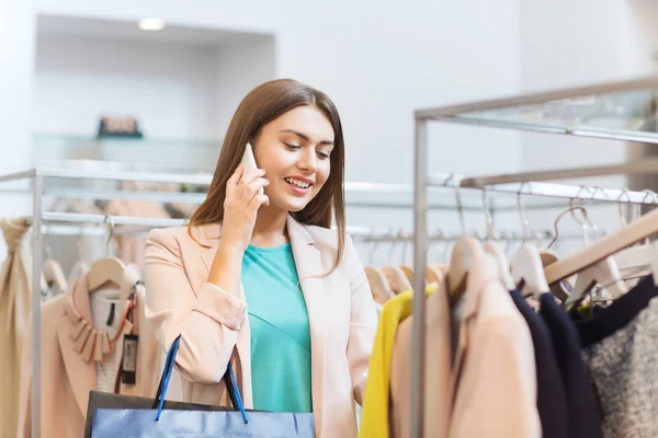 Feliz jovem mulher escolhendo roupas no shopping — Fotografia de Stock