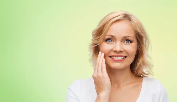 Femme souriante en t-shirt blanc touchant son visage — Photo