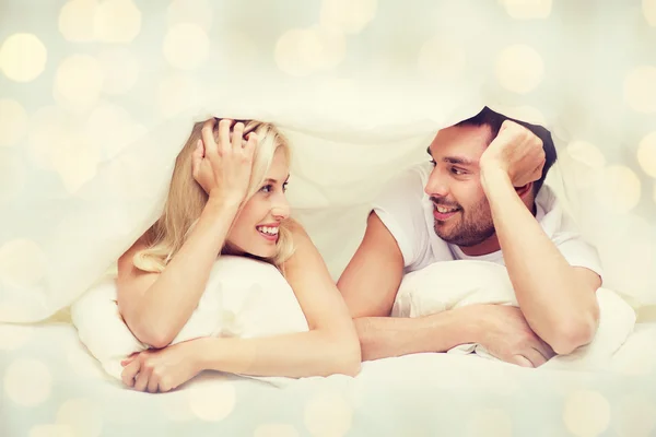 Glückliches Paar liegt im Bett und spricht zu Hause — Stockfoto