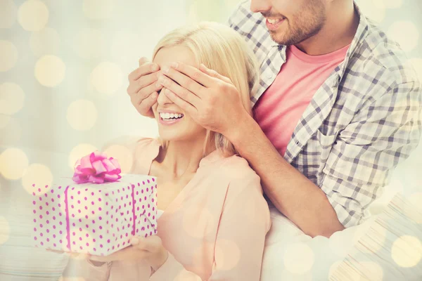 Hombre feliz dando mujer caja de regalo en casa — Foto de Stock