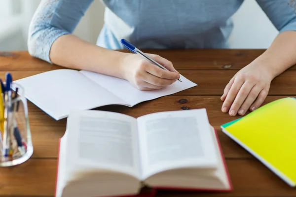 Nahaufnahme eines Studenten mit Buch und Notizbuch zu Hause — Stockfoto