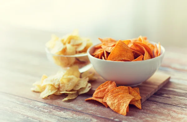 Close up of potato crisps and nachos in glass bowl — Stock Photo, Image