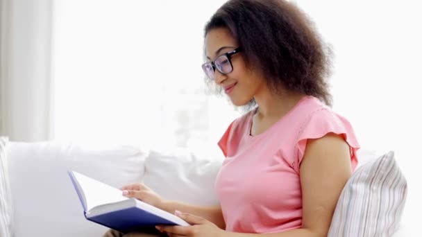 Joven afroamericana leyendo libro en casa — Vídeos de Stock