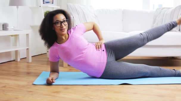 Happy african woman exercising on mat at home — Stock Video