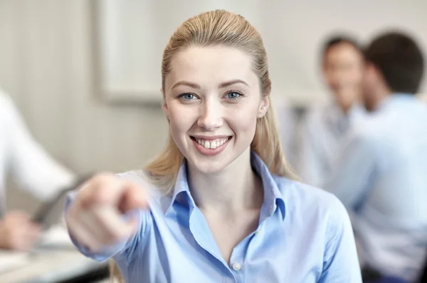 Sorridente empresária apontando dedo em você — Fotografia de Stock