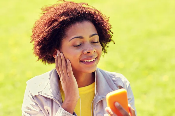 Gelukkig Afrikaanse vrouw met smartphone en oortelefoons — Stockfoto