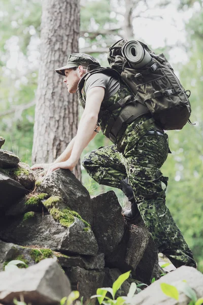 Jovem soldado com mochila na floresta — Fotografia de Stock