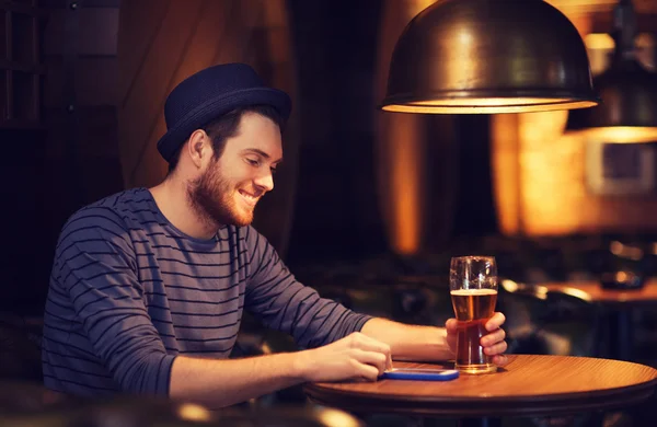 Homme avec smartphone et bière textos au bar — Photo