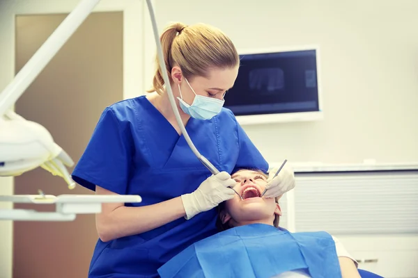 Kvinnliga tandläkare kontrollera patientens tjej tänder — Stockfoto