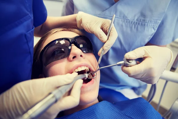 Dentistas mujeres que tratan los dientes de niña paciente — Foto de Stock